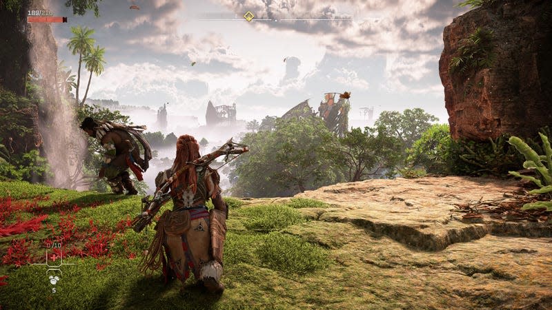 A PS5 screenshot shows Aloy standing on a cliff overlooking an overgrown launch pad. 