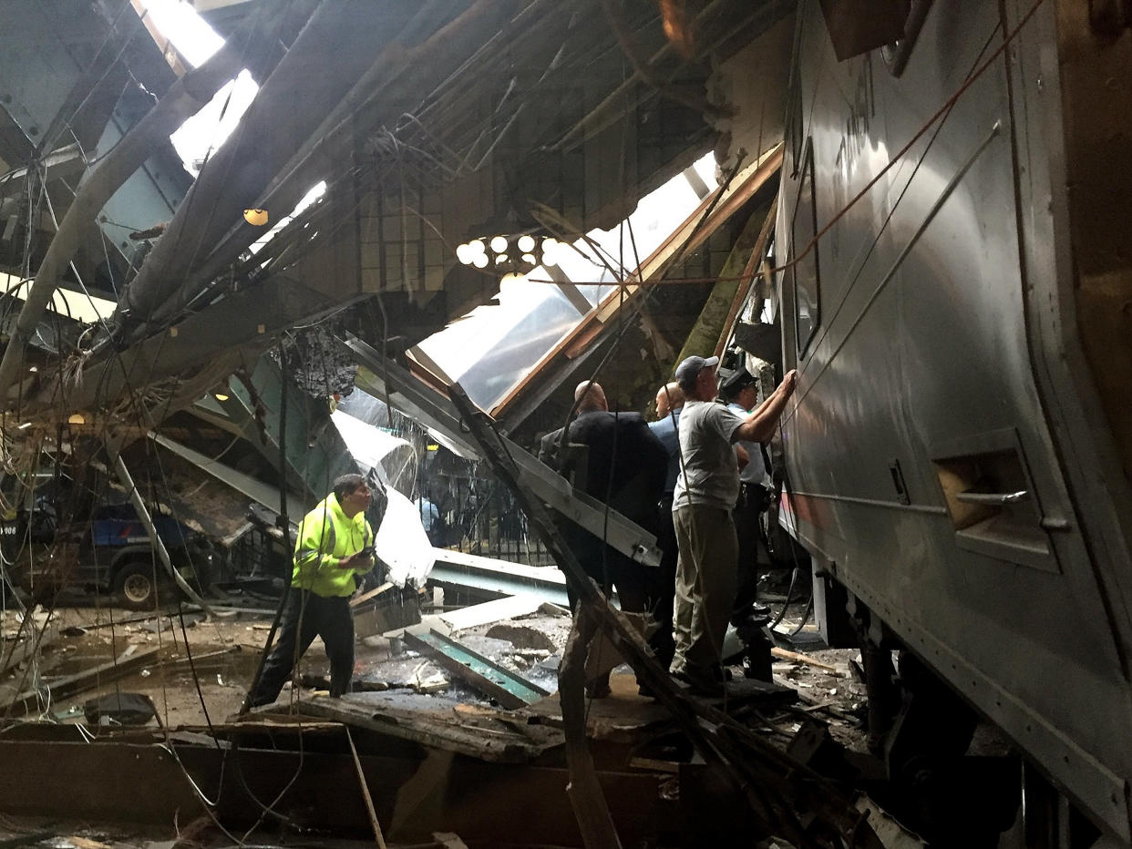 Train personnel survey the New Jersey Transit train that crashed into the platform at the Hoboken Terminal on Thursday morning.