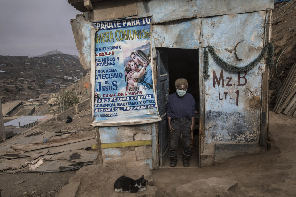 Julia Bertila Pérez, de 83 años, posa para una foto en su puerta en el barrio Nueva Esperanza de Lima, Perú, el sábado 30 de mayo de 2020. (AP Foto/Rodrigo Abd)