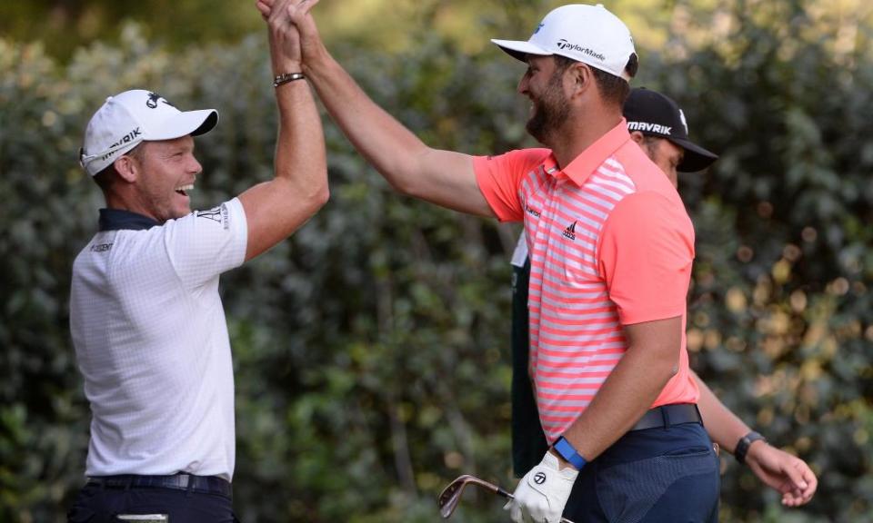 Jon Rahm celebrates after a hole-in-one on the 17th hole with his playing partner Danny Willett. The Spaniard shot a course-record 61 to sit four shots off the lead.