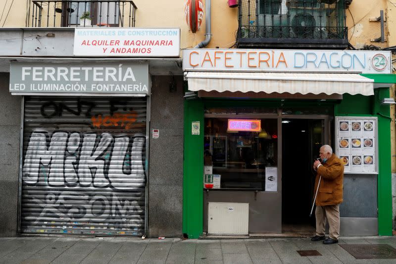 A man smokes a cigarette next to a closed business during the coronavirus disease (COVID-19) outbreak in Madrid