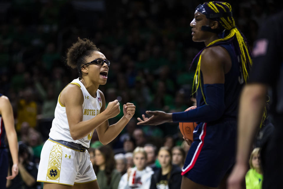 Notre Dame's Olivia Miles (5) celebrates as Connecticut's Aaliyah Edwards (3) questions a call during the second half of an NCAA college basketball game on Sunday, Dec. 4, 2022, in South Bend, Ind. (AP Photo/Michael Caterina)