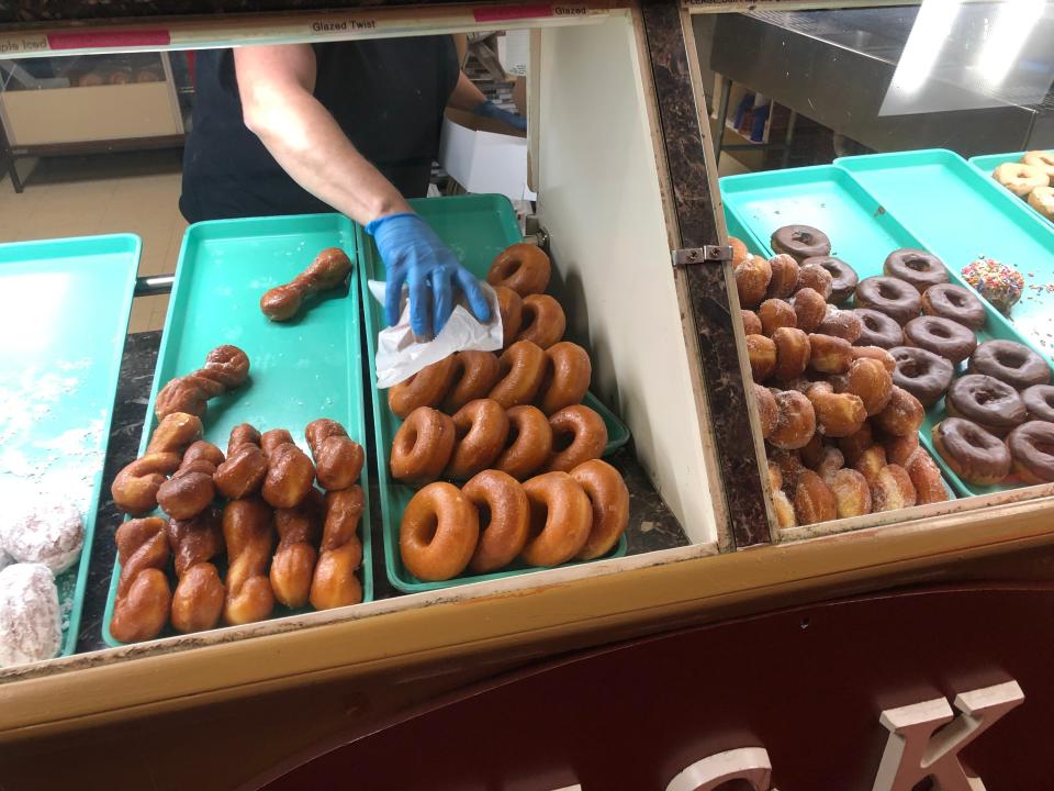 Crystal Smith fills a box of assorted freshly made doughnuts at Hu0026K Donuts, 3712 West Lake Road, Millcreek Township.