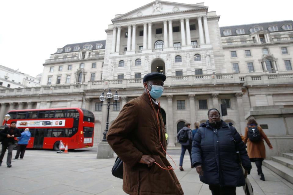A man, wearing a protective face mask, walks in front of the Bank of England: REUTERS
