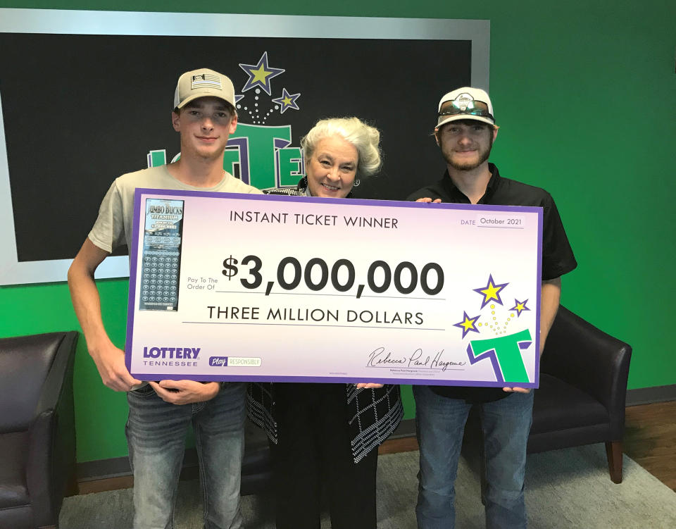 Winner Wyatt Close, Tennessee Lottery President and CEO Rebecca Paul Hargrove, and winner Brandon Thompson show off the $3 million check they took home for a $30 scratch-off lottery ticket. (Courtesy Tennessee Lottery)