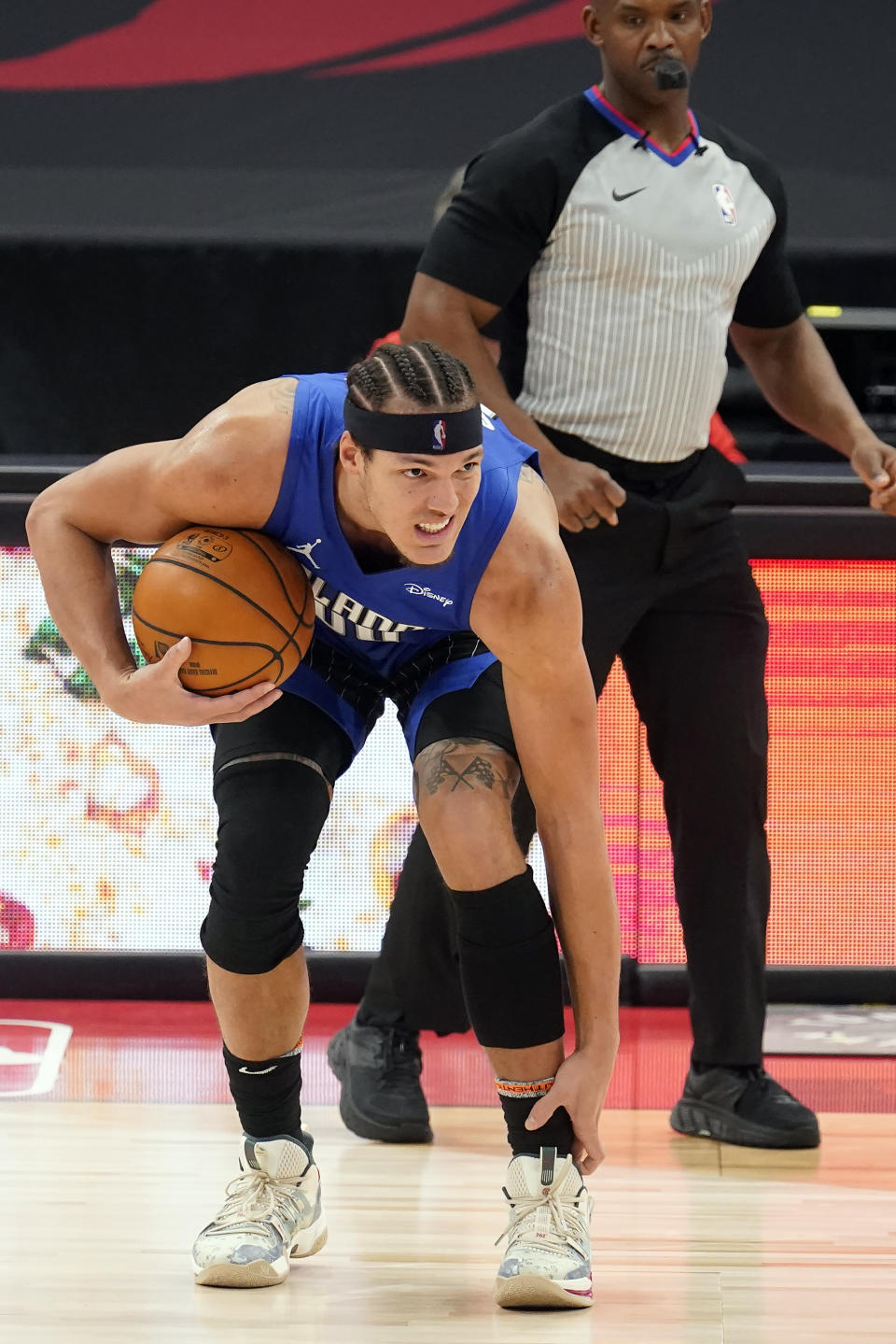 Orlando Magic forward Aaron Gordon (00) grabs his ankle after attempting to drive up the court during the second half of an NBA basketball game against the Toronto Raptors Sunday, Jan. 31, 2021, in Tampa, Fla. Gordon left the game. (AP Photo/Chris O'Meara)
