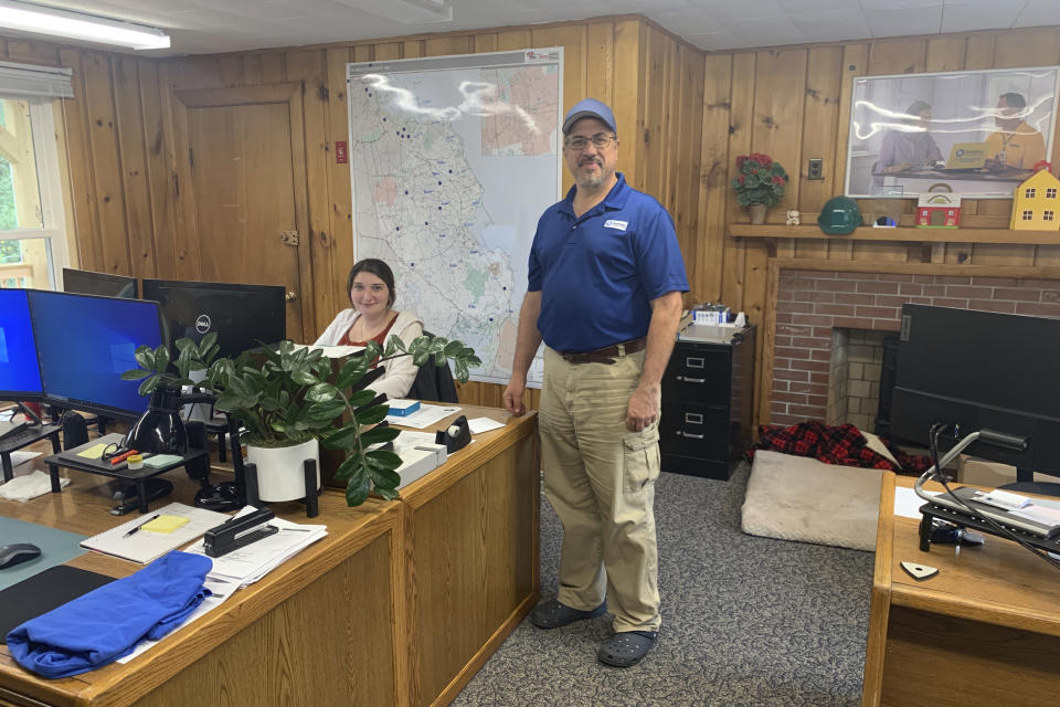 Daniel Edwards stands with Kylie Vaughan, a customer service representative, at his Handyman Connection franchise office in Hanover, Mass., on Aug. 22, 2022. Edwards has seen bookings slow and customers being tighter with money. (Courtesy Daniel Edwards via AP)