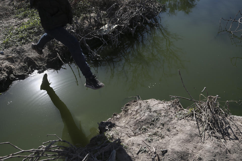 A migrant jumps over the Rio Grande river into the United States from Ciudad Juarez, Mexico, Wednesday, March 29, 2023, a day after dozens of migrants died in a fire at a migrant detention center in Ciudad Juarez.(AP Photo/Christian Chavez)