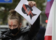 A women's rights activist with a poster of the Women's Strike action protests in Warsaw, Poland, Wednesday, Oct. 28, 2020 against recent tightening of Poland's restrictive abortion law. Massive nationwide protests have been held ever since a top court ruled Thursday that abortions due to fetal congenital defects are unconstitutional. (AP Photo/Czarek Sokolowski)