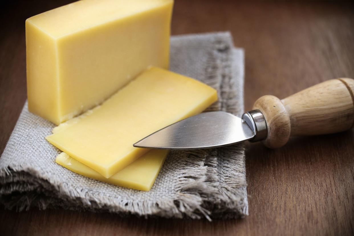 block of cheese with knife on table