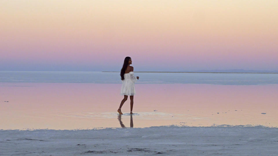 A visitor poses for a photograph at the Bonneville Salt Flats on Friday, Oct. 7, 2022, near Wendover, Utah. (AP Photo/Rick Bowmer)