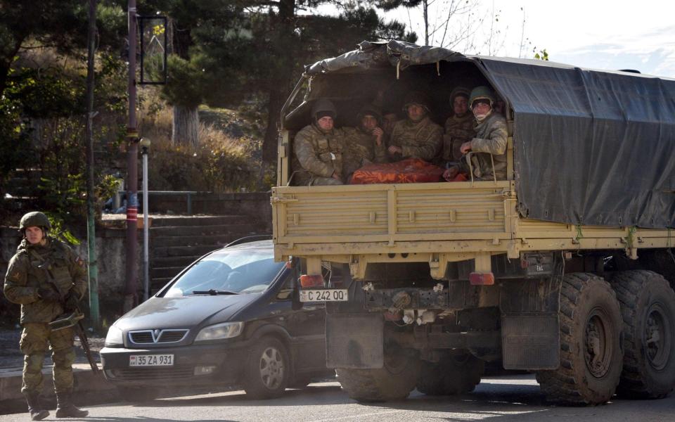 Azerbaijani soldiers ride in the back of a truck through the town of Lachin - KAREN MINASYAN/AFP via Getty Images