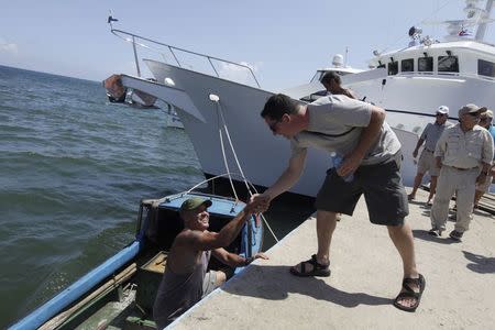 Patrick Hemingway (R), the grandson of the U.S. author Ernest Hemingway, shakes hands with a fisherman in Cojimar village, Havana September 8, 2014. REUTERS/Enrique De La Osa