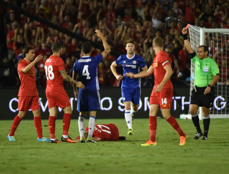 Chelsea's Cesc Fabregas (3rd L) receives a red card after fouling Liverpool's Ragnar Klavan (on ground)