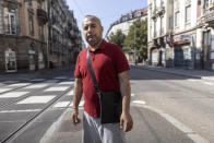 Afghanistan's Abdul Wali poses in the middle of a street in Strasbourg, eastern France, Sunday, Sept. 4, 2021. Wali took the last bus out of a huge makeshift migrant camp in the northern French port of Calais. His government bus took him to Strasbourg. “Now, I’m so happy to be here,” he said. “You’re not scared at night” like in the migrant camp nicknamed The Jungle. “You have your job. You have your work, you come back home. You pay your rent. You are a normal person.” (AP Photo/Jean-Francois Badias)