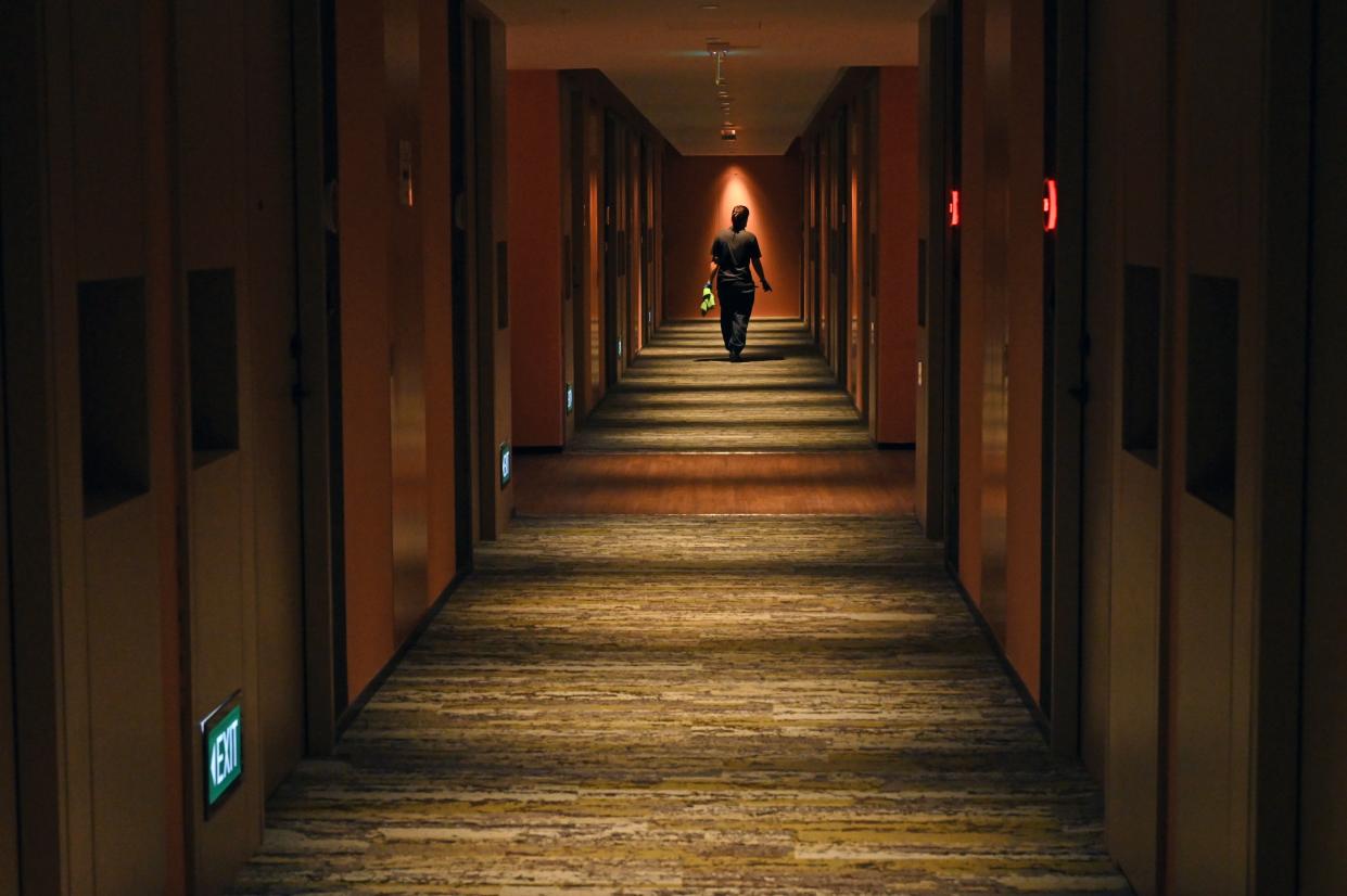 A housekeeper walks along a corridor of guests rooms at a hotel in Singapore. 