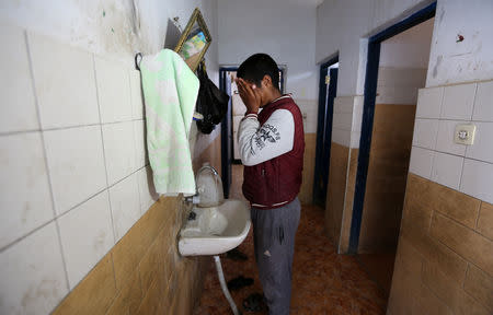 Palestinian songbird catcher Hamza Abu Shalhoub, 16, washes his face at the family house in Rafah in the southern Gaza Strip November 8, 2018. Picture taken November 8, 2018. REUTERS/Ibraheem Abu Mustafa