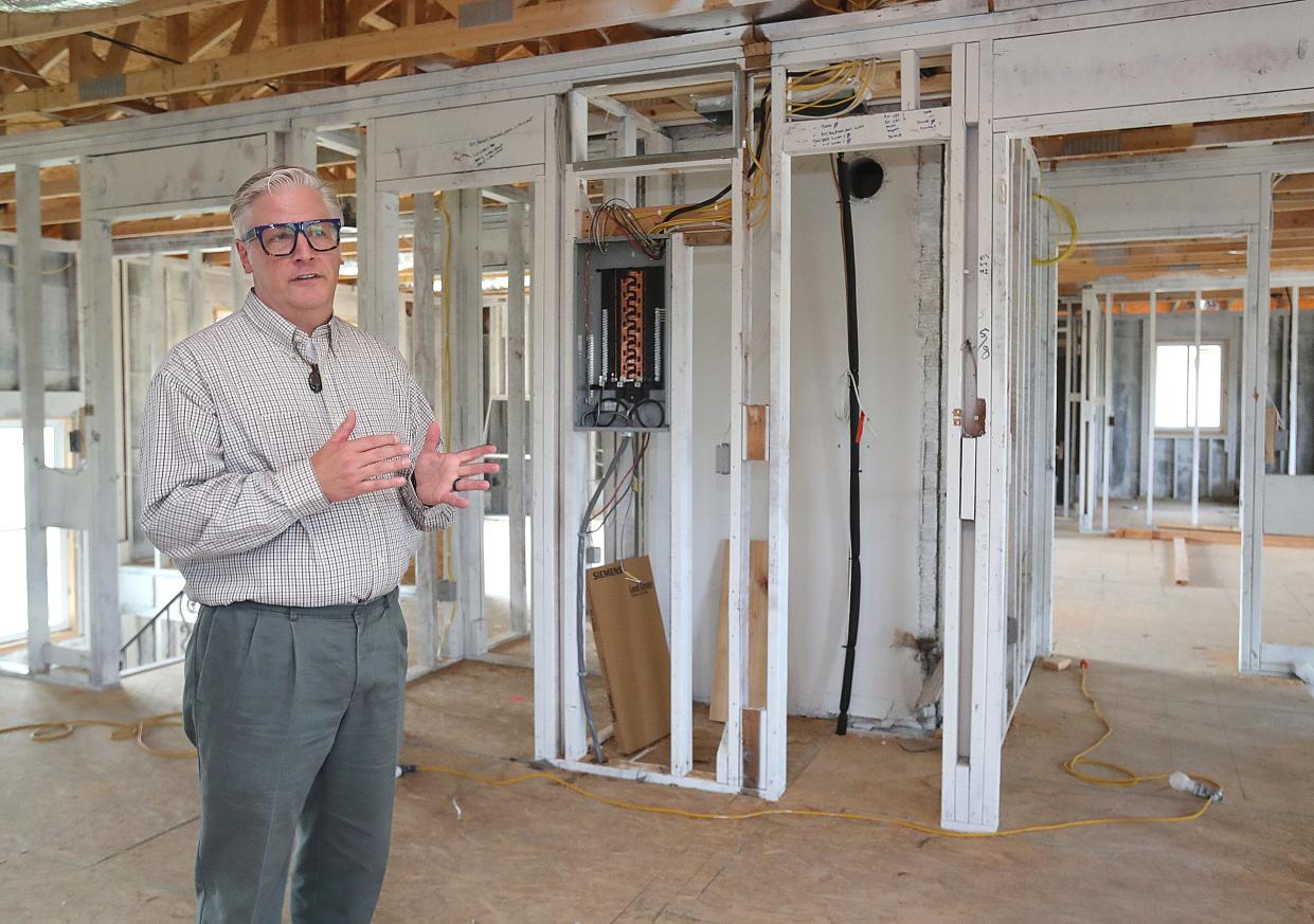 Fred Berry, president and CEO of Humility of Mary Housing, talks about construction work needed to complete restoration of a fire-damaged apartment building Wednesday on Treeside Drive in Northwest Akron.