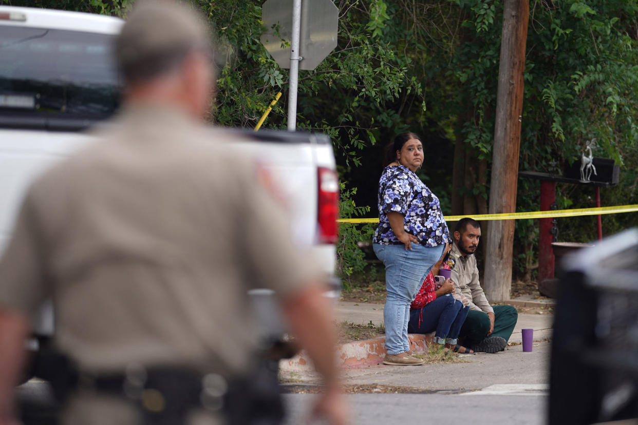 People sit on the curb outside of Robb Elementary School (Allison Dinner / AFP via Getty Images)