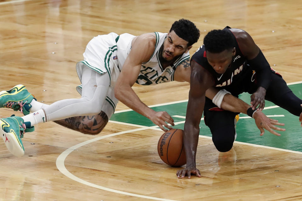 Boston Celtics' Jayson Tatum (0) and Miami Heat's Victor Oladipo compete for the ball during the second half of Game 3 of the NBA basketball playoffs Eastern Conference finals Saturday, May 21, 2022, in Boston. (AP Photo/Michael Dwyer)