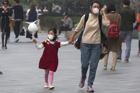A woman and child wear masks during a hazy day in Beijing, China, Oct. 14, 2016.