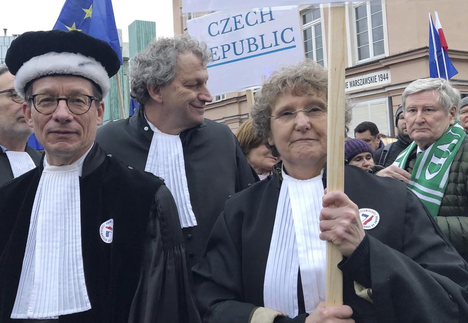 Judges from Italy, the Netherlands and elsewhere in Europe, many wearing their professional gowns, take part in a march in support of judicial independence in Warsaw, Poland, on Saturday Jan. 11, 2020. The judges marched silently in Warsaw in a show of solidarity with Polish peers who are protesting a bill that would allow the government to fire judges who issue rulings officials don't like. (AP Photo/Vanessa Gera)