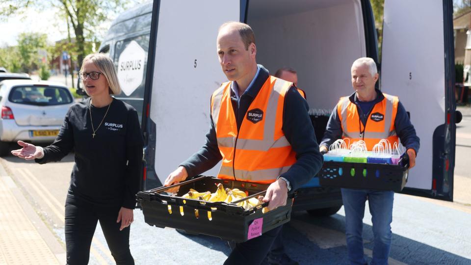 Prince William carries a crate of bananas