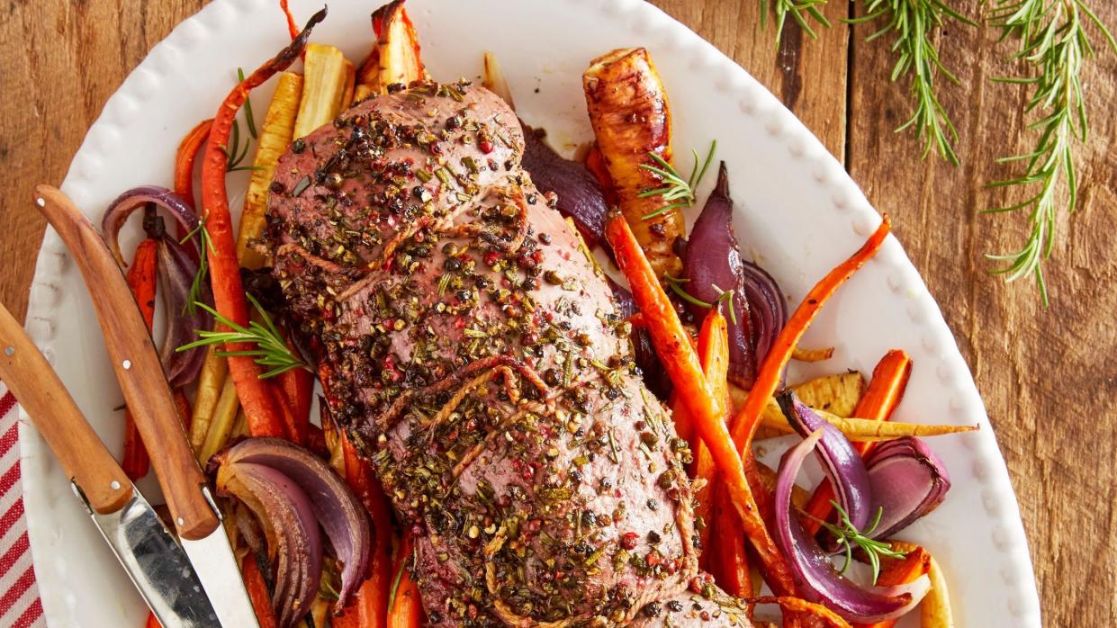 rosemary beef tenderloin with root vegetables on an oval white serving plate