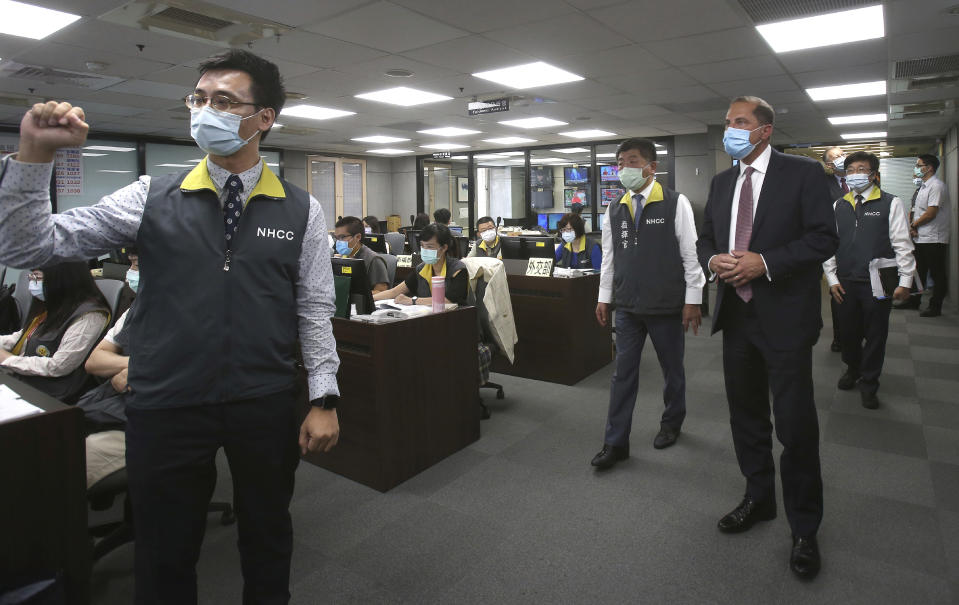 U.S. Health and Human Services Secretary Alex Azar, right, visits the the National Health Command Center with Taiwanese Minister of Health and Welfare Chen Shih-chung, center, at the Central Epidemic Command Center in Taipei, Taiwan, Monday, Aug. 10, 2020. Azar arrived in Taiwan on Sunday in the highest-level visit by an American Cabinet official since the break in formal diplomatic relations between Washington and Taipei in 1979. (AP Photo/Chiang Ying-ying)