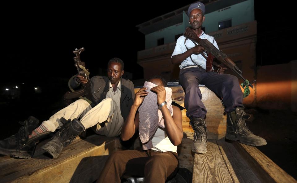 Somali security forces detain a suspect at the scene of an explosion in front of Maka Al-Mukarama hotel in Mogadishu March 11, 2015. One person was killed in the suicide car explosion outside the renowned hotel, local media said. REUTERS/Feisal Omar (SOMALIA - Tags: CIVIL UNREST CRIME LAW)