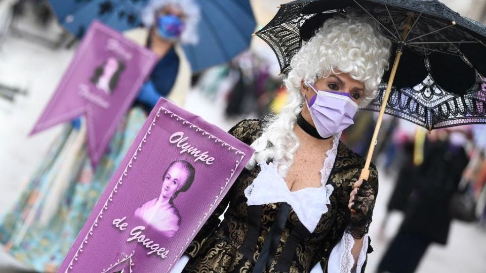 Mujeres disfrazadas llevando carteles con la imágen de Olympe de Gouges, en el Día Internacional de la Mujer 2021 en Valencia, España.