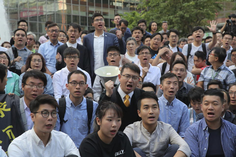 Newly-elected pro-democracy district council members chant slogans as they gather near the Polytechnic University in Hong Kong, Monday, Nov. 25, 2019. Hong Kong's pro-democracy opposition won a stunning landslide victory in weekend local elections in a clear rebuke to city leader Carrie Lam over her handling of violent protests that have divided the semi-autonomous Chinese territory. (AP Photo/Kin Cheung)