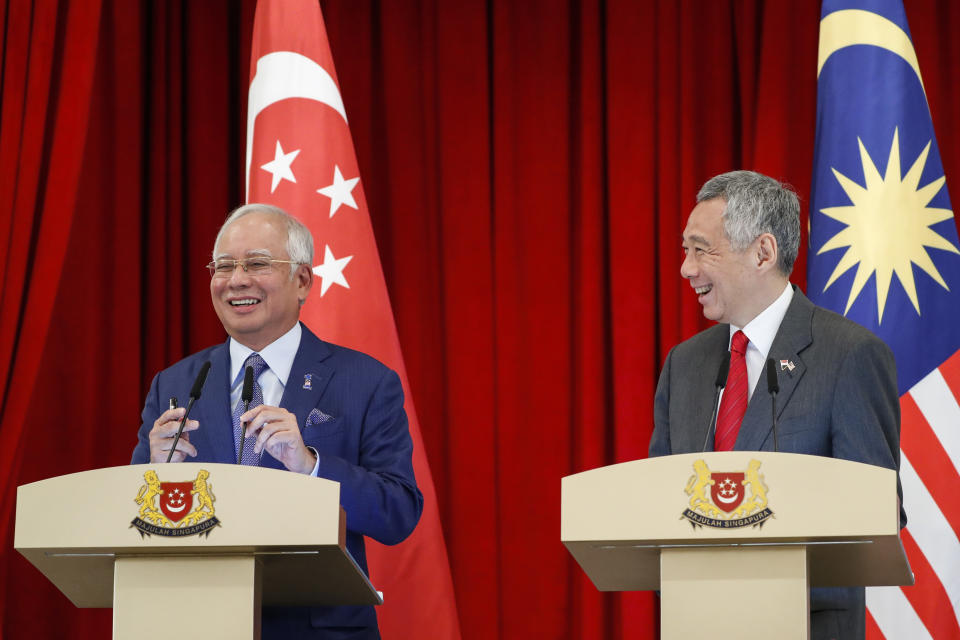 Malaysia’s Prime Minister Najib Razak, left, and his Singaporean counterpart Lee Hsien Loong, laugh as they speak at a joint press conference during the Singapore-Malaysia Leaders’ Retreat at the Istana or presidential palace in Singapore, Tuesday, Jan. 16, 2018. (AP Photo/Yong Teck Lim)
