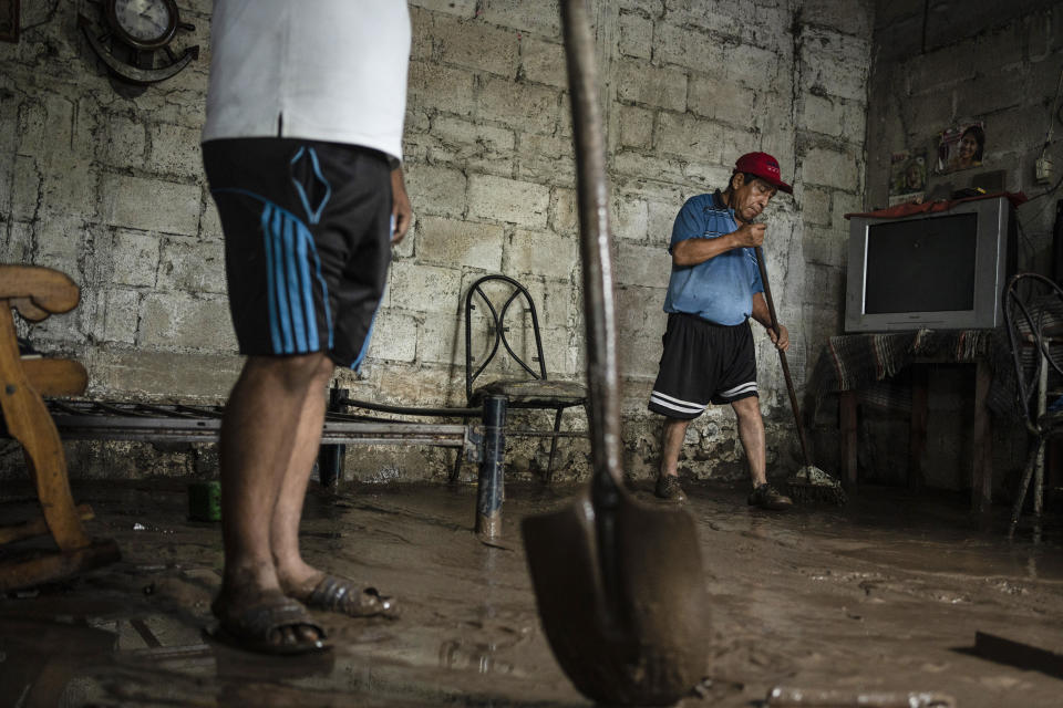 Eduardo Sedas and his son clean his house, which was affected by the overflowing of the Actopan River in Ursulo Galvan, Veracruz, Mexico, Monday, July 1, 2024. A tropical depression formed Sunday night near the port of Veracruz in eastern Mexico. (AP Photo/Felix Marquez)