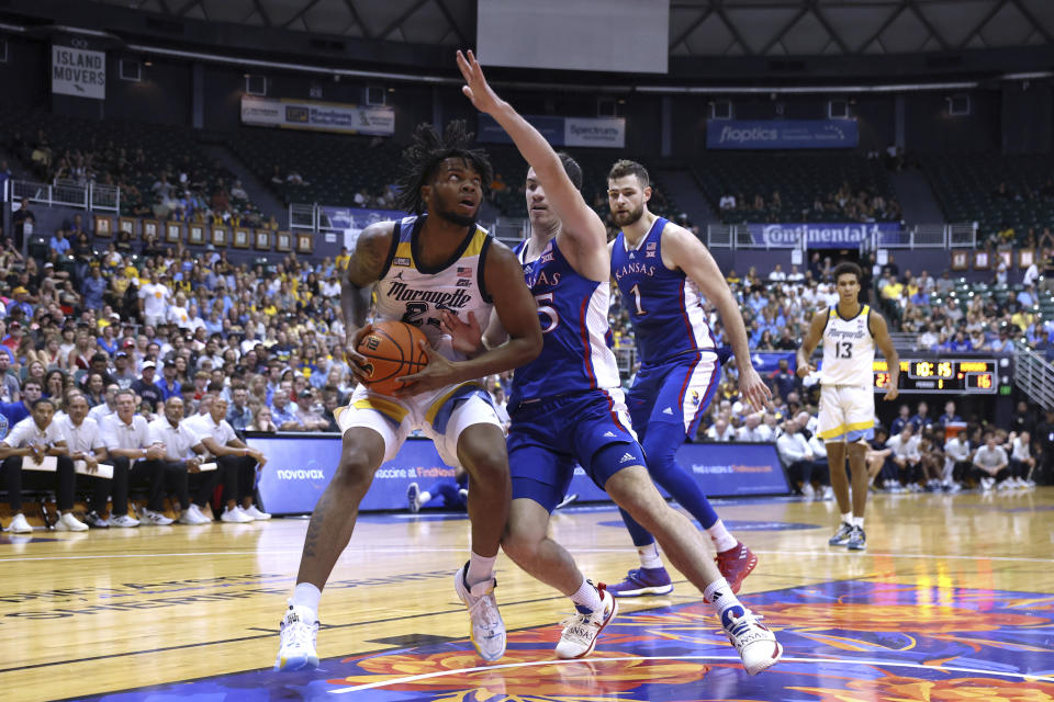 Marquette forward David Joplin (23) looks for the net as Kansas guard Nicolas Timberlake (25) defends during the first half of an NCAA college basketball game Tuesday, Nov. 21, 2023, in Honolulu. (AP Photo/Marco Garcia)