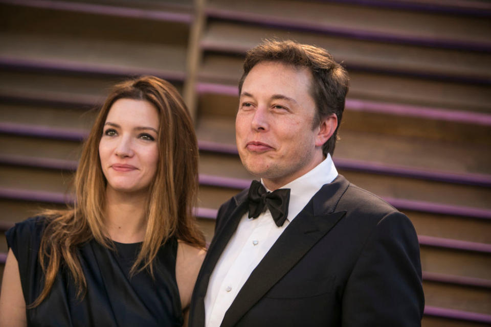 Elon in a bow tie standing next to a woman