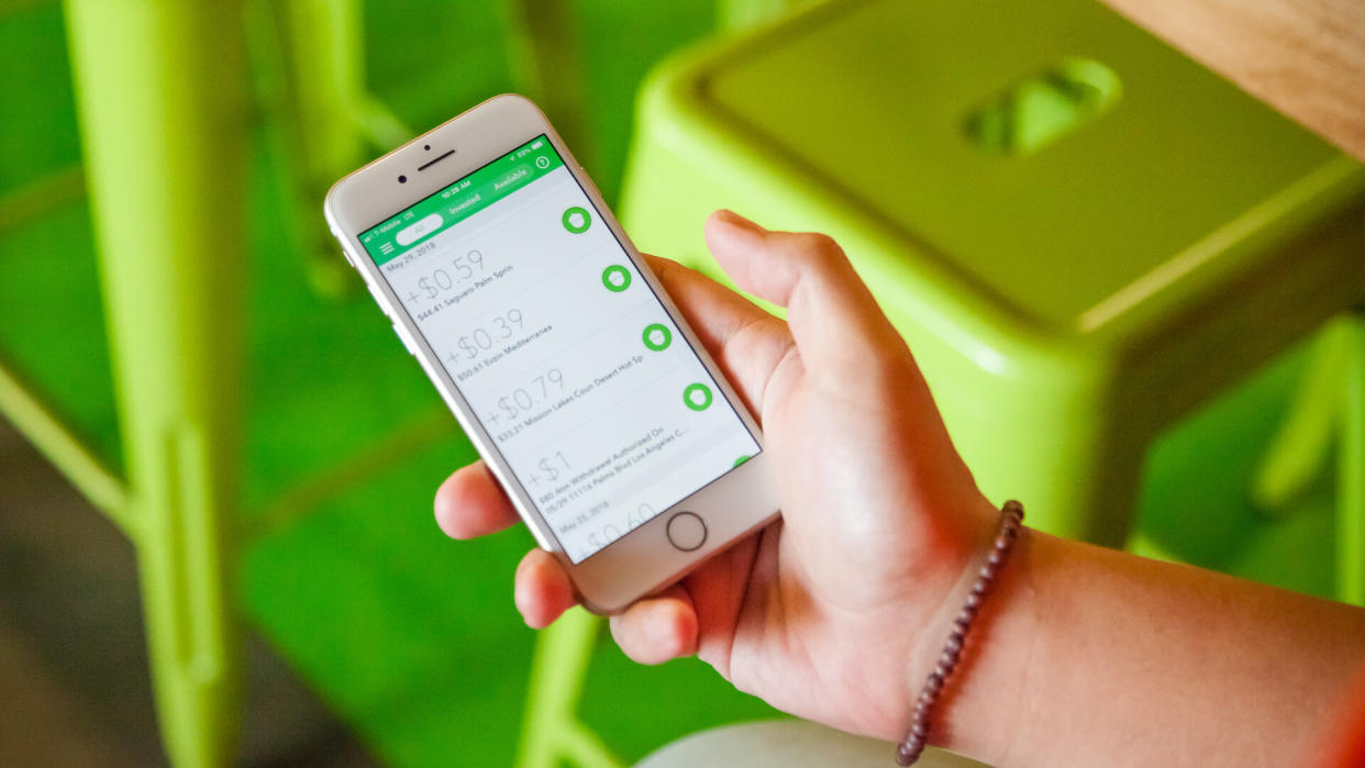 person using Acorns stock app.