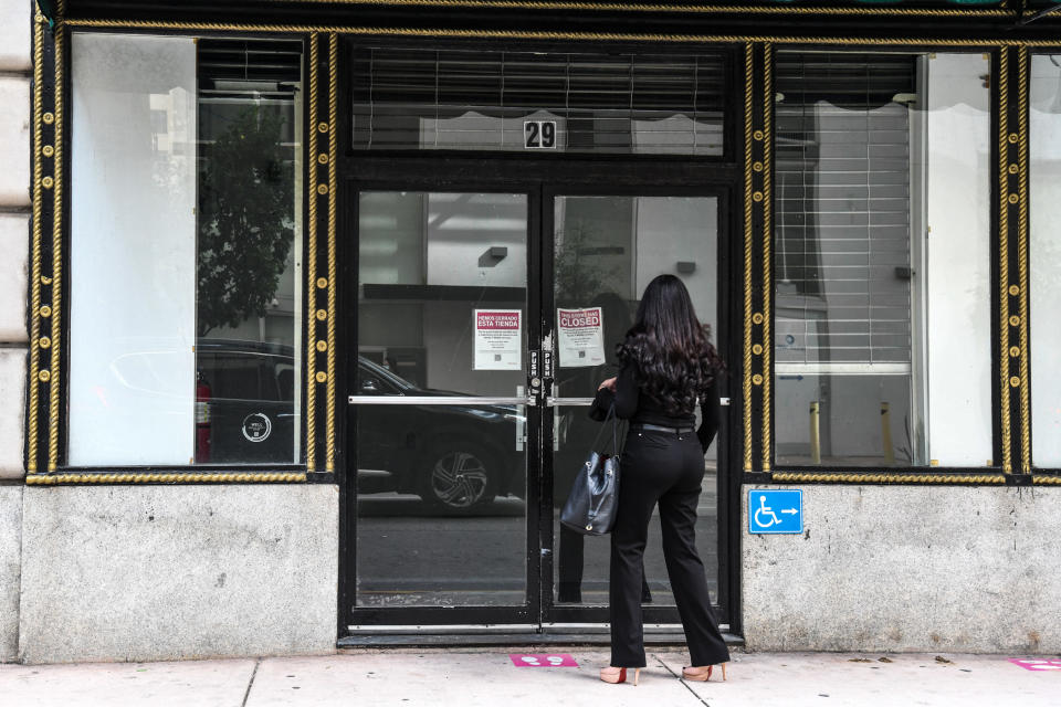 Une femme lit le panneau affiché dans un magasin fermé à Miami le 12 janvier 2022. (Photo de CHANDAN KHANNA/AFP)