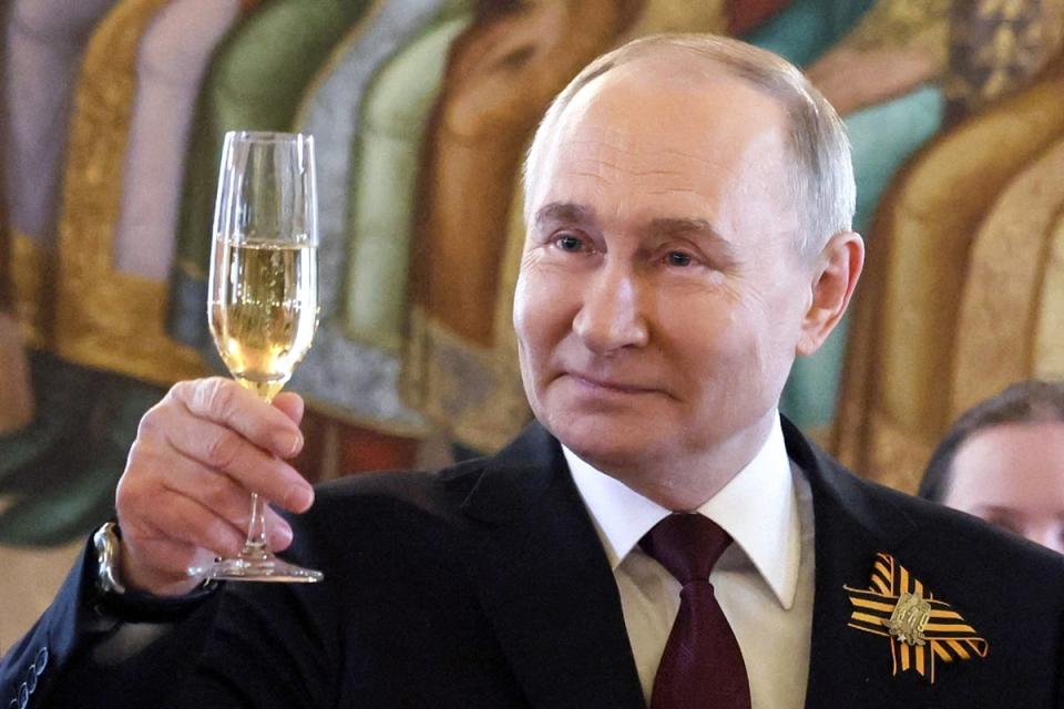 Putin raises a toast during a ceremony following the parade (Reuters)