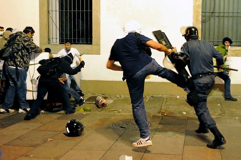 Demonstrators clash with riot police in front of Rio de Janeiro's legislative building on June 17, 2013. Police used tear gas, pepper spray and rubber bullets to disperse small groups of masked youths engaging in acts of vandalism near the assembly