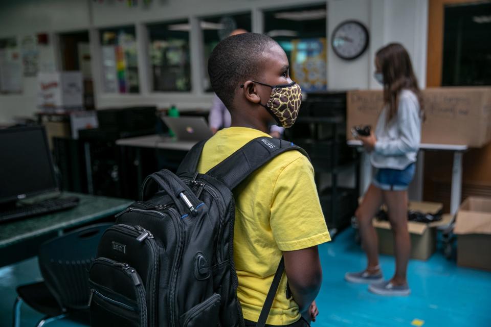 A student waits to receive a Chromebook at Rippowam Middle School on September 14, 2020 in Stamford, Connecticut. Most students at the middle school are taking part in a hybrid model, where they attend in-school classes every other day and distance learn with Chromebooks the rest of the school week. More than 20 percent of students in the Stamford Public Schools district are enrolled in the distance learning option only, due to coronavirus concerns.