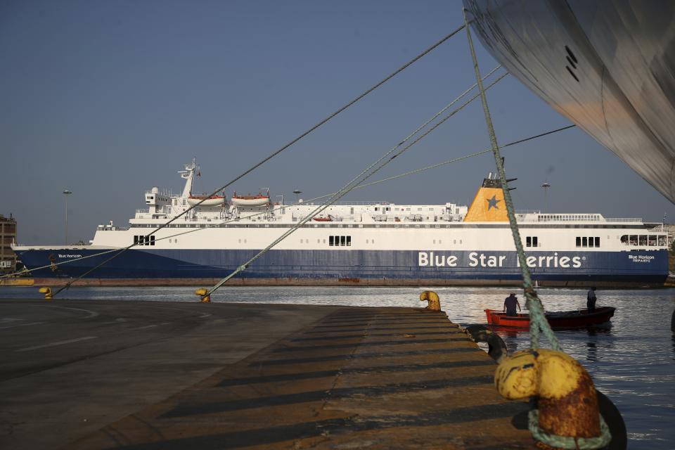 Workers on a boat clean the sea during seamen's unions strike at the port of Piraeus, near Athens, Monday, Sept. 3, 2018. Ferries are due to be halted by a 24-hour strike Monday, as unions seek the return of benefits and pay scales scrapped or frozen during eight years of international bailouts that ended in late August. (AP Photo/Thanassis Stavrakis)