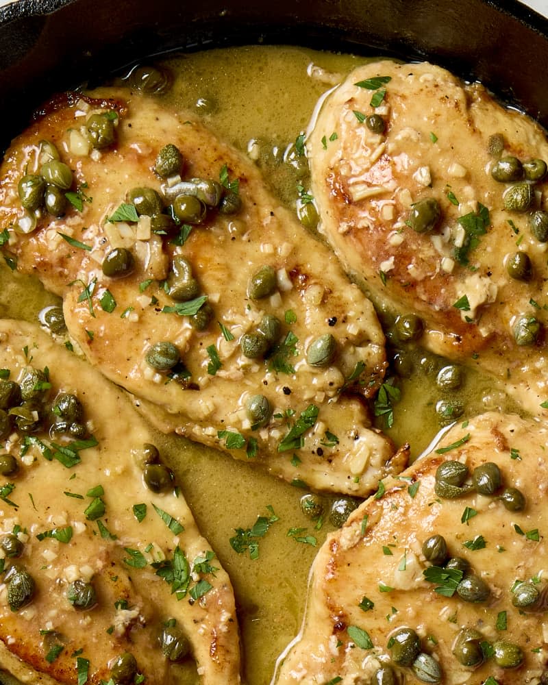 overhead shot of chicken piccata in a cast iron pan.