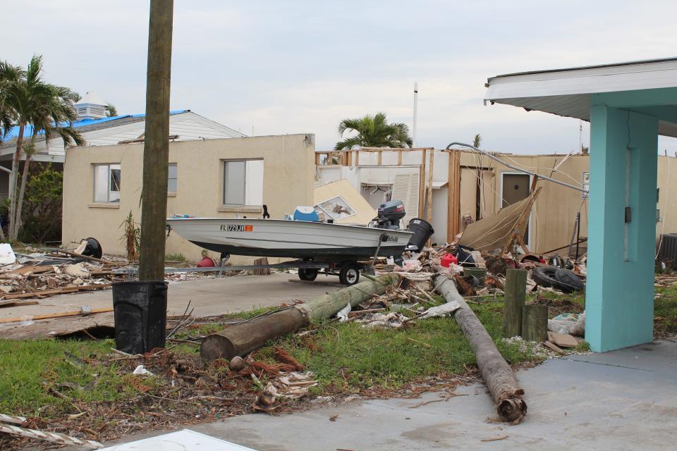 Matlacha homes saw significant damage from Hurricane Ian's fierce winds and storm surge, some becoming unlivable. A home along Bridgeview Street is completely gutted, with debris scattered across the yard and palm street penetrating the walls.