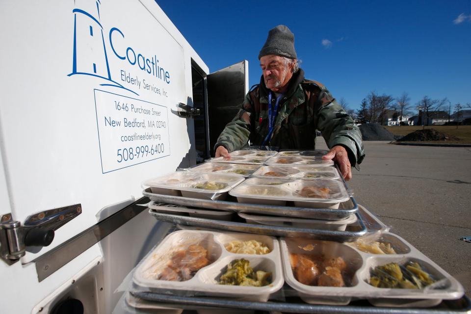 Michael Parris Heuberger loads freshly made meals onto the Coastline Elderly's Meals on Wheels delivery vehicle at the Senior Center at Brooklawn Park in New Bedford.