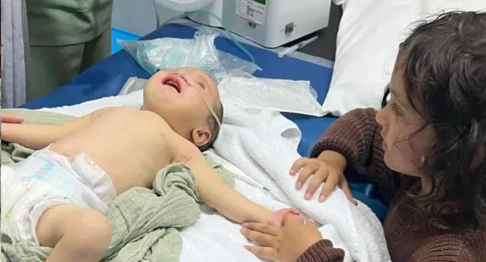 Lucky on a hospital bed holding the hand of her four-year-old brother Hendrix. Source: GoFundMe