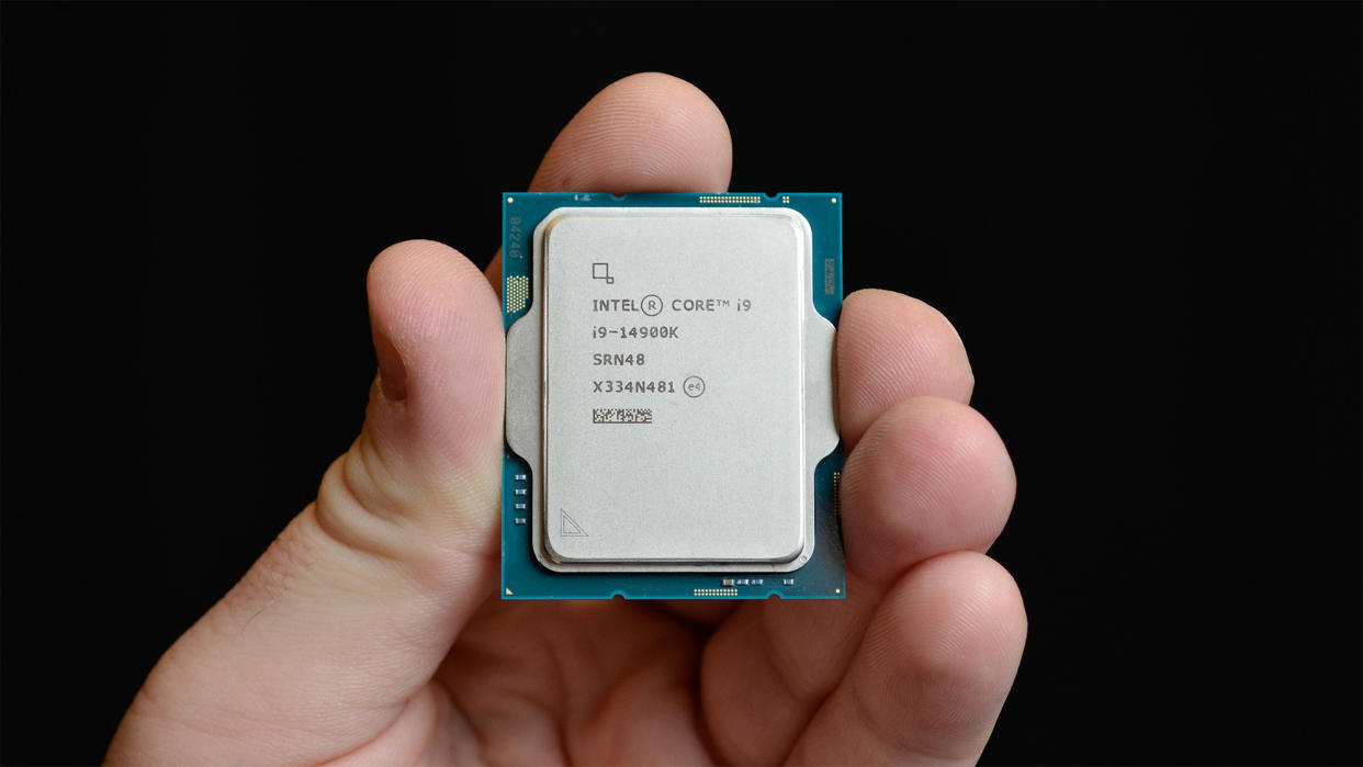  A masculine hand holding an Intel Core i9-14900K. 