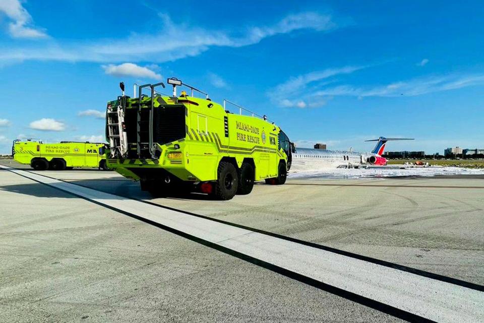 In this photo released by the Miami-Dade Fire Rescue Department, Miami-Dade Fire Rescue crews works at the scene of an aircraft fire at Miami International Airport