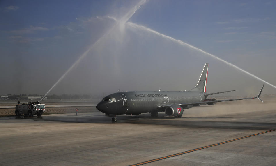 FILE - Plumes of water form an arch over an air force plane transporting Mexico's President Andres Manuel Lopez Obrador in a water salute during the inauguration of a new runway at the Santa Lucia military air base north of Mexico City, Feb. 10, 2021. The airport was finished and inaugurated on March 21, 2022, but it remains little-used (AP Photo/Marco Ugarte)