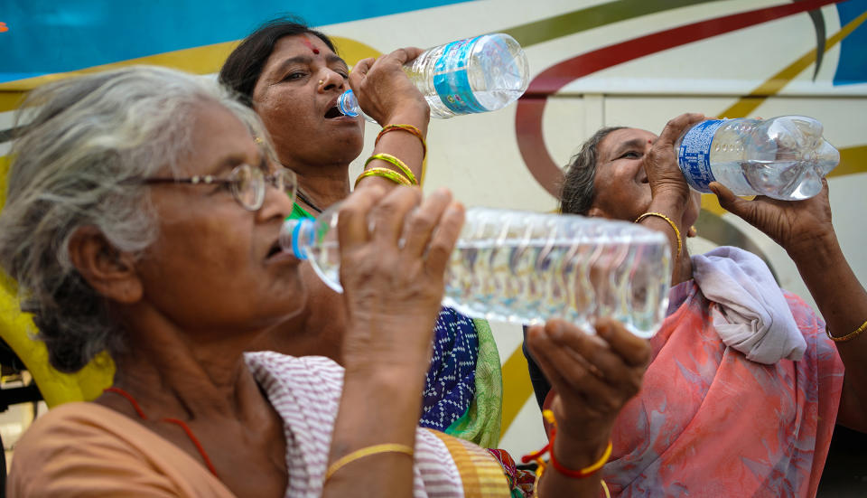 Women drinking water from water bottles on a hot summer day in Kolkata, India on April 13. According to the IMD special bulletin, an orange alert has been announced for the districts of South Bengal during April 12-16.<span class="copyright">Sudipta Das—NurPhoto/Reuters</span>